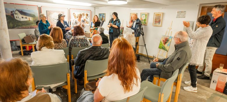 Künstlerinnen und Zuschauer bei der Vernissage einer Kunstausstellung