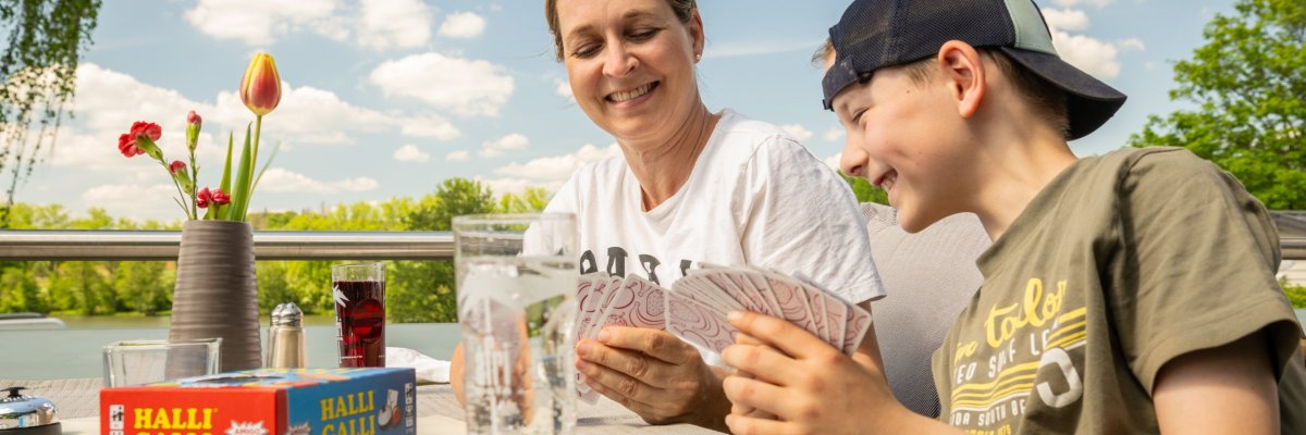 Eine Mutter und ihr Sohn sitzen an einem Picknicktisch in Rennerod und Secker Weiher im Hohen Westerwald und genießen gemeinsam die naturnahe Örtlichkeit.